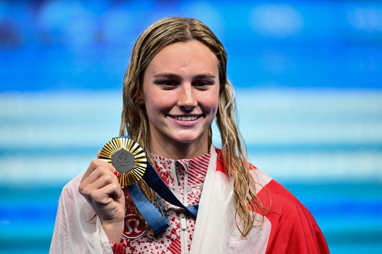 Gold medallist Canada's Summer Mcintosh celebrates during the podium ceremony of the women's 200m individual medley swimming event during the Paris 2024 Olympic Games at the Paris La Defense Arena in Nanterre, west of Paris, on August 3, 2024. (Photo by Manan VATSYAYANA / AFP)