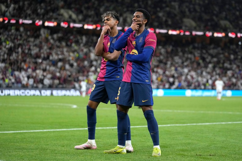 Barcelona's Alejandro Balde, right, and Barcelona's Lamine Yamal react during the Spain Super Cup final soccer match between Real Madrid and Barcelona at King Abdullah Stadium in Jeddah, Saudi Arabia, Sunday, Jan. 12, 2025. (AP Photo/Altaf Qadri)